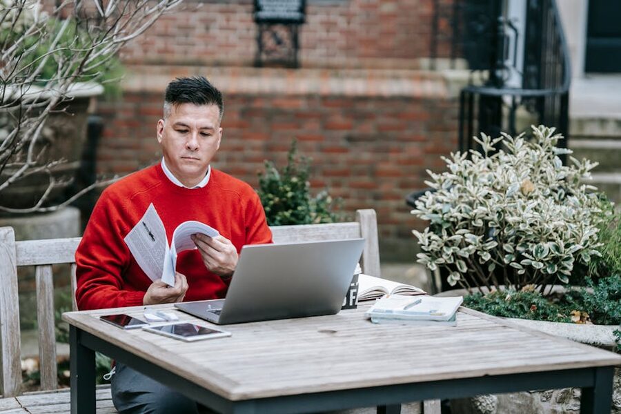 Traveller researching a hotel on a laptop outside
