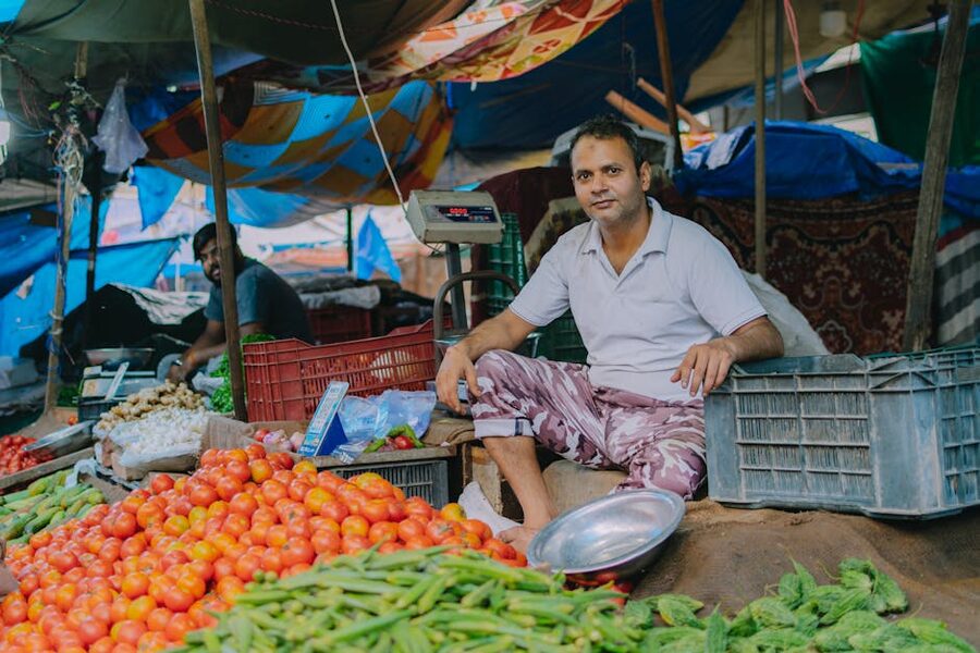 A vendor at a local street market with fresh vegetables