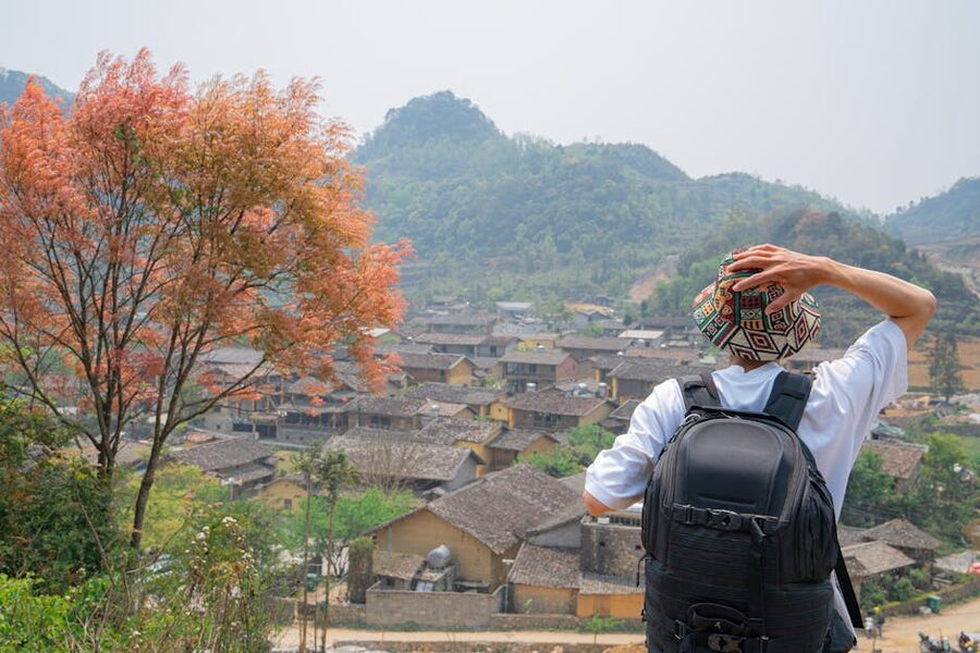 Backpacker overlooking a small mountain village, framing sustainable tourism around host communities