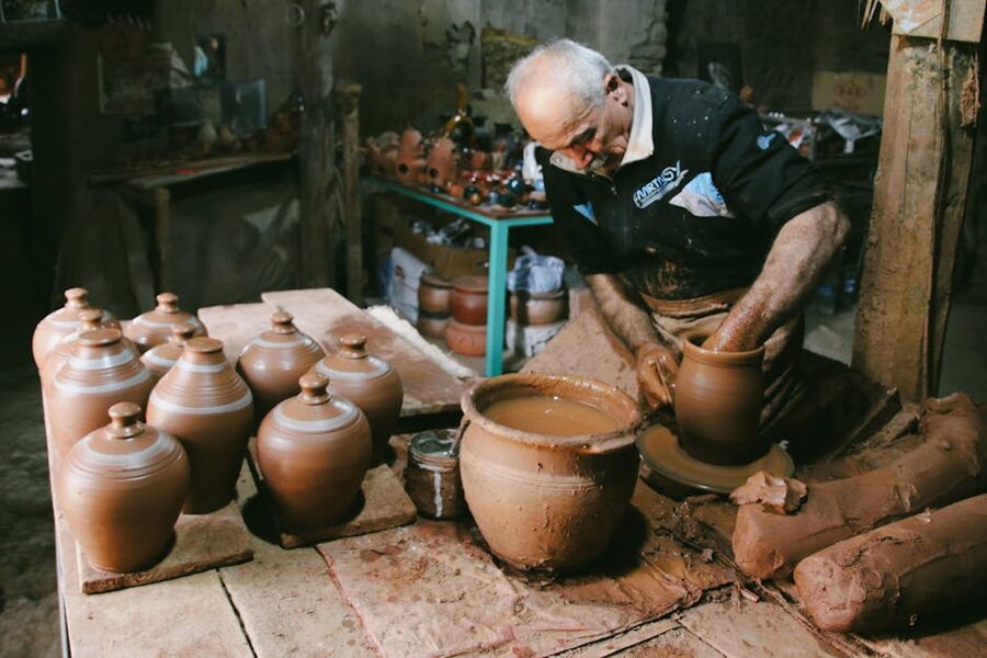 Senior man making pottery jugs in a traditional workshop