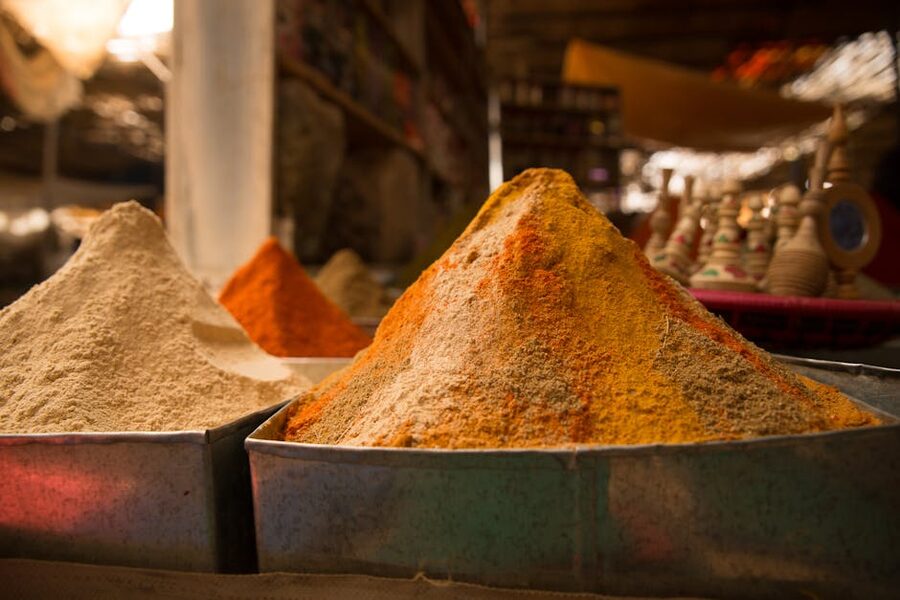 Colorful spices in metal containers at an open-air market