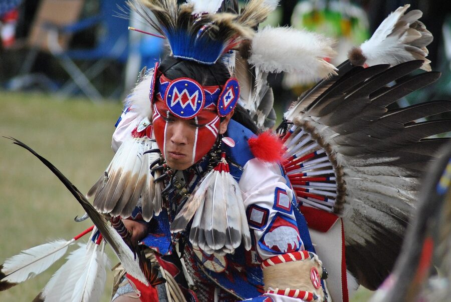 A dancer in regalia at a Native American powwow