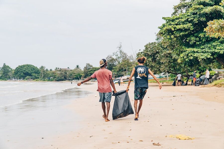 Volunteers carrying trash bags during a beach cleanup