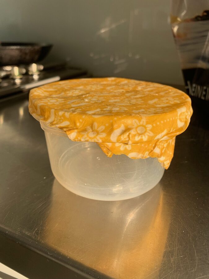 Beeswax wrap covering a glass bowl on a kitchen counter
