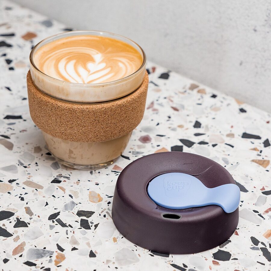 Cork-sleeved KeepCup reusable coffee cup on a wooden surface