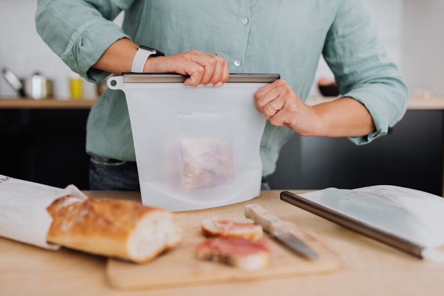 Reusable silicone food storage bag being filled in a kitchen