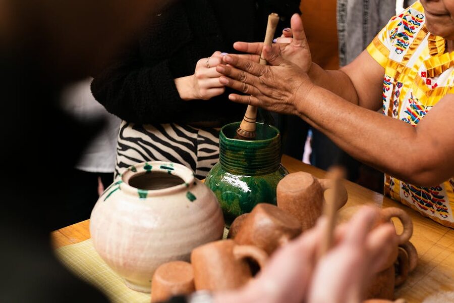 Close-up of hands shaping clay pots at a pottery workshop in Oaxaca