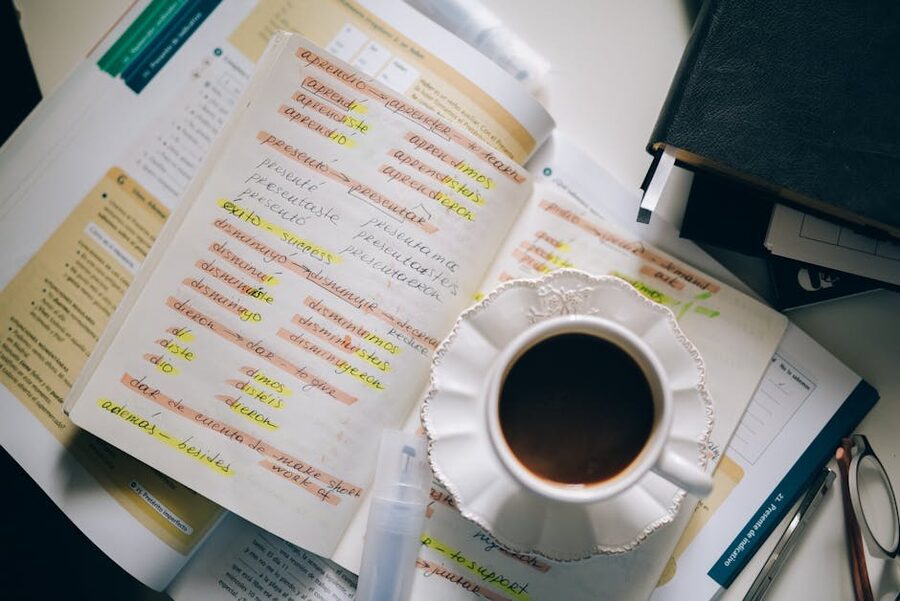 A coffee cup resting on handwritten Spanish language-learning notes