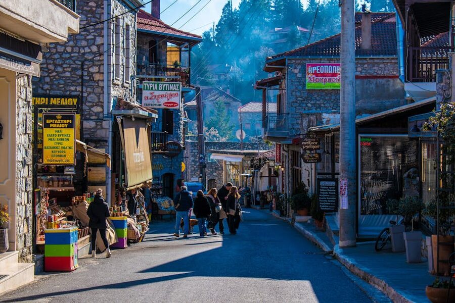 A village street in Vytina, Greece, with small local stores along a sunny lane